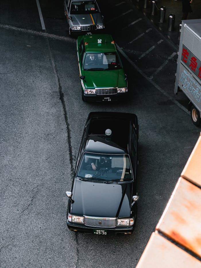 A top-down view of taxis lined up on an urban street, showcasing city transportation.